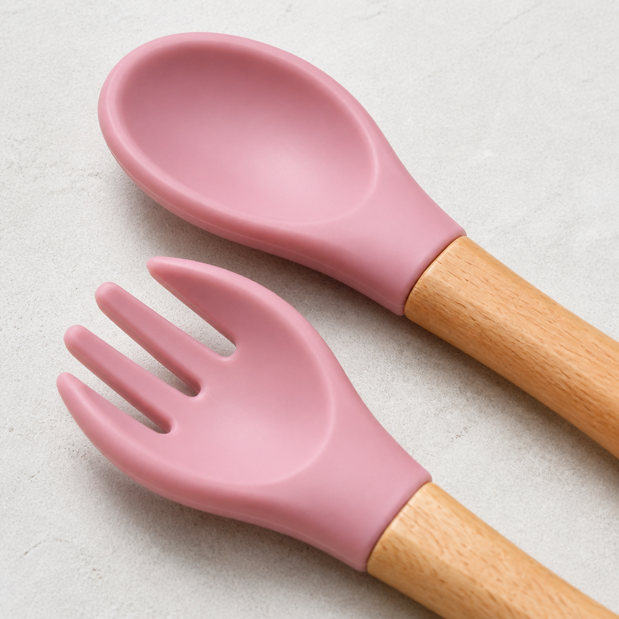 Close-up of YumBella silicone spoon and fork heads with natural wood handles